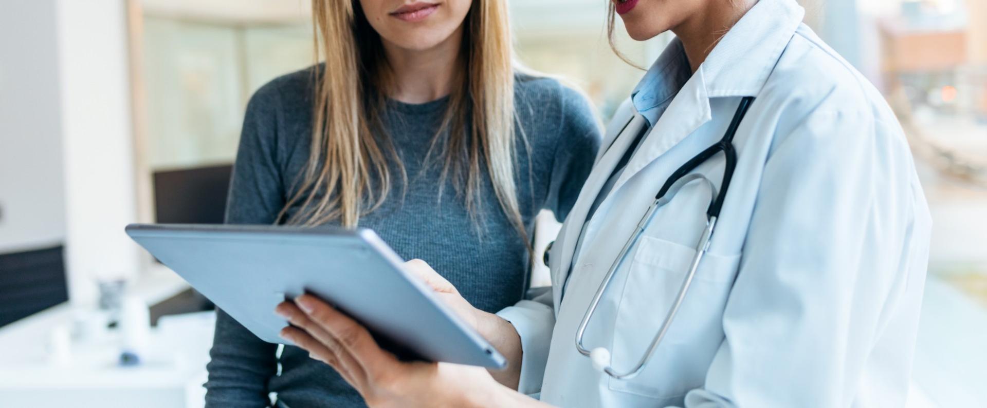 Medico e paziente discutono i risultati su un tablet in uno studio medico.